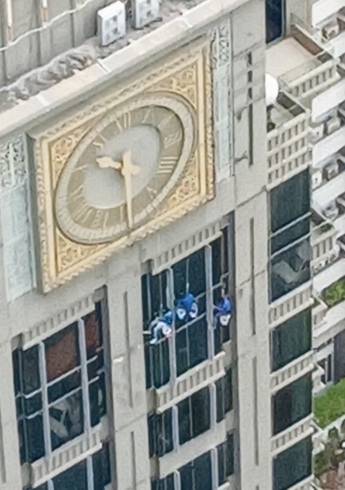 A crew of workmen wash windows in a residential building in Sathorn. This image -at a large zoom magnification- is reminiscent of 1920s comedy films of Harold Lloyd.